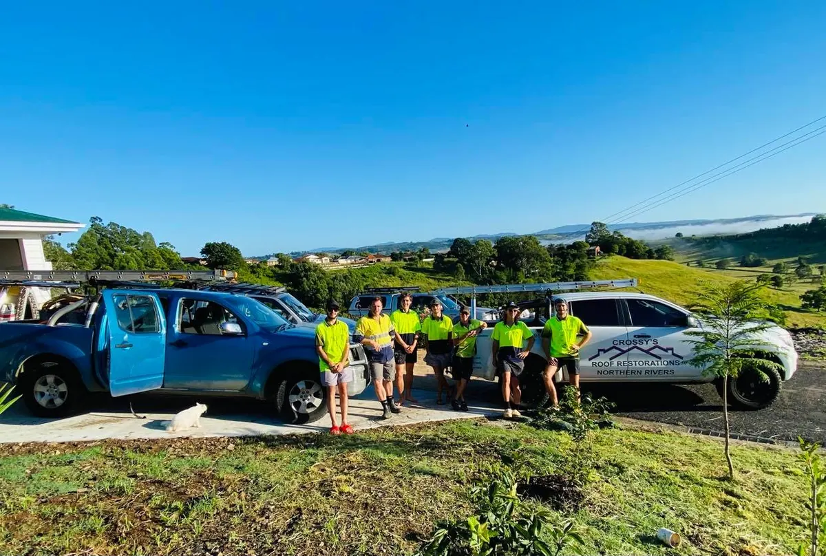 The Crossy's Roof Restorations crew in front of a branded work vehicle